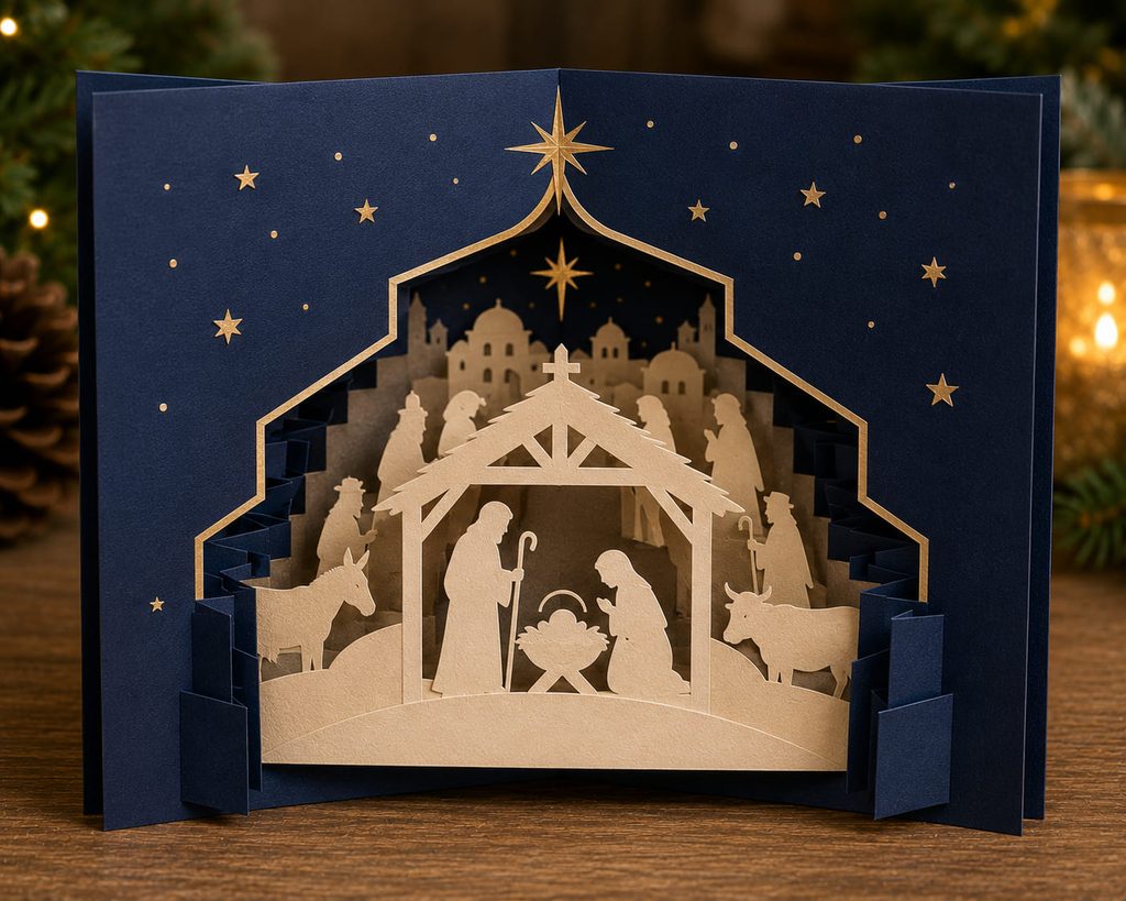 Layered nativity tunnel card with cream paper silhouettes and a star aperture inside midnight-blue cardstock.